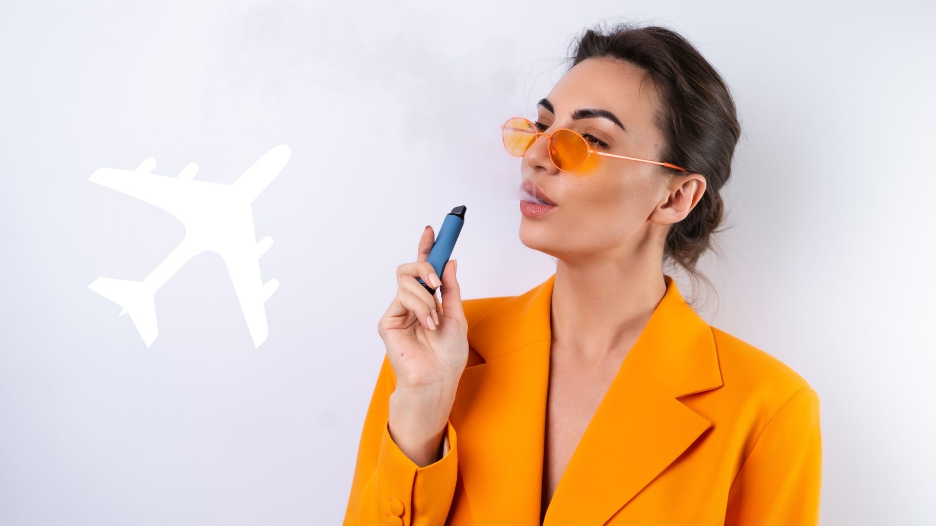 Frau in orangefarbenem Blazer, die ein Vape mit einer weißen Flugzeuggrafik in der Hand hält.