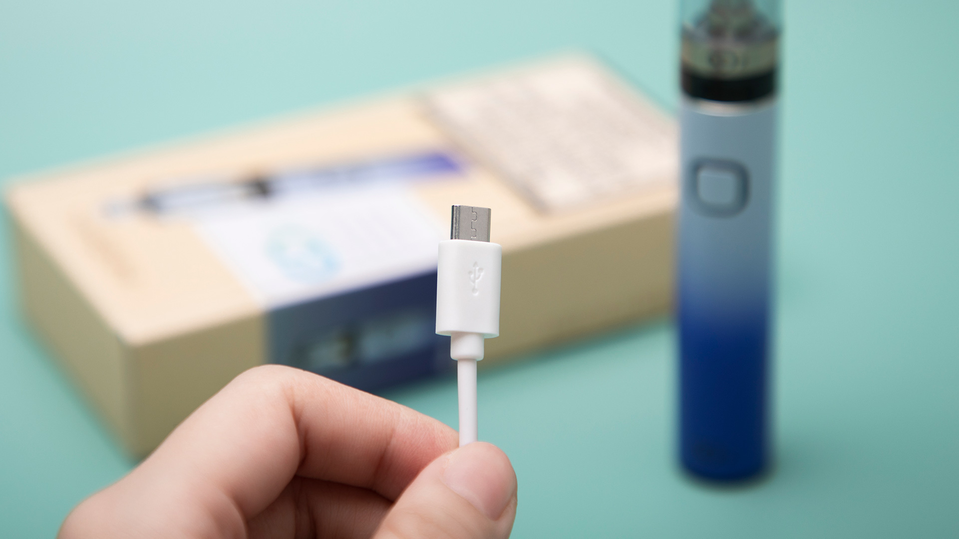 Nahaufnahme eines Vape Pen-Ladegeräts, das in der Hand gehalten wird und Probleme beim Aufladen anspricht.