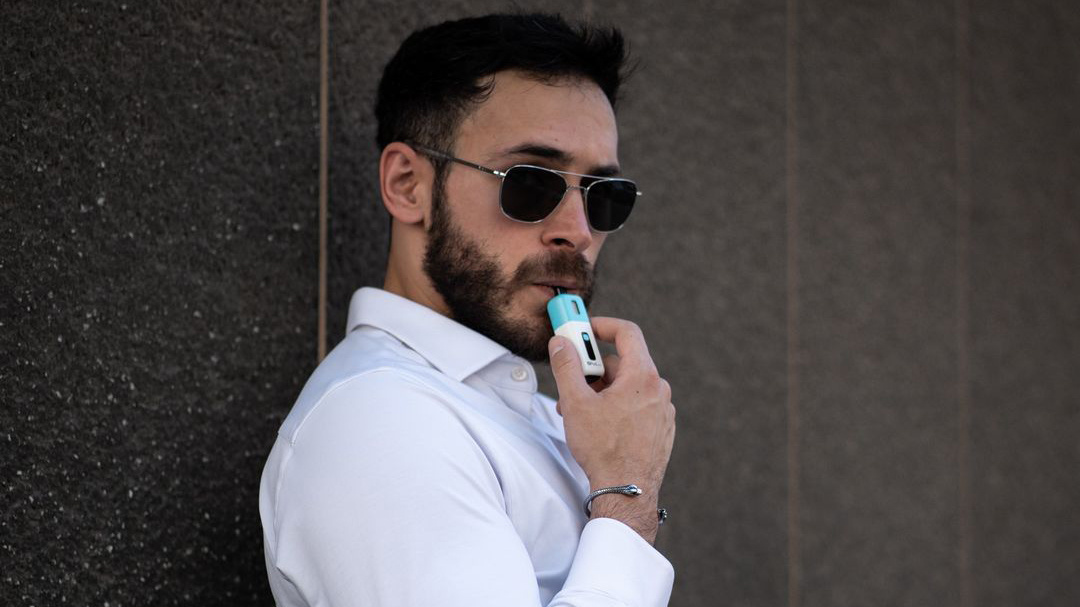 Stilvoller Mann mit Z Pod Nano, der nachfüllbare Vapes für starke Raucher empfiehlt