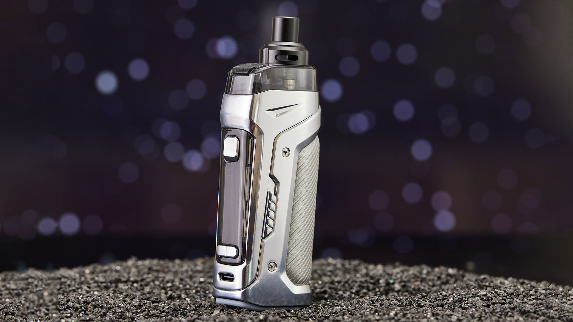 Innokin Coolfire PZPulse Pod-Vape in elegantem silbernem Design, stehend auf einer strukturierten schwarzen Oberfläche mit Bokeh-Hintergrund.