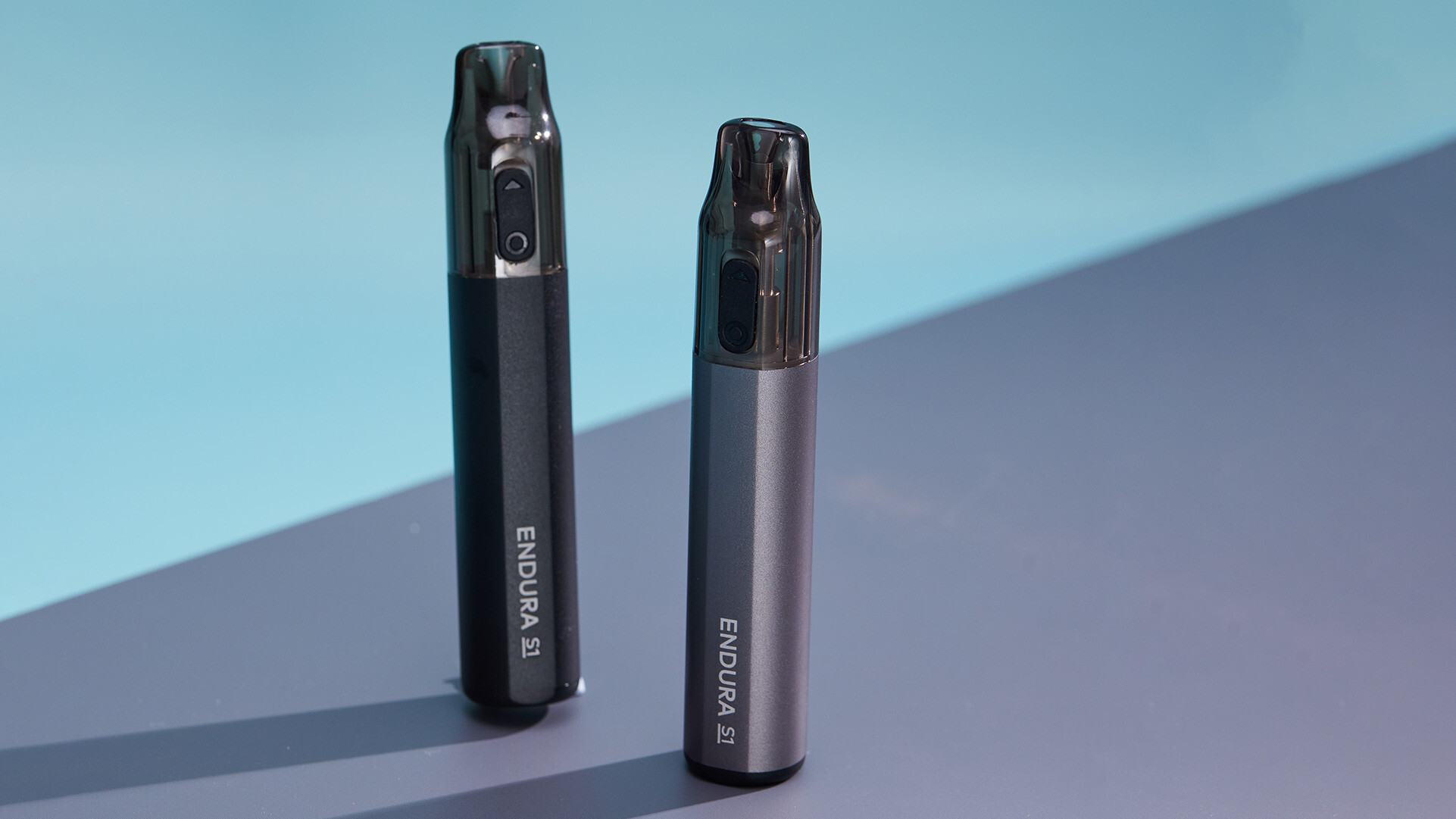 Zwei ENDURA S1 wiederaufladbare Einweg-Vape-Pens, einer in Schwarz und einer in Silber, die ihr schlankes Design und ihre einfachen Identifikationsmerkmale zur Schau stellen.