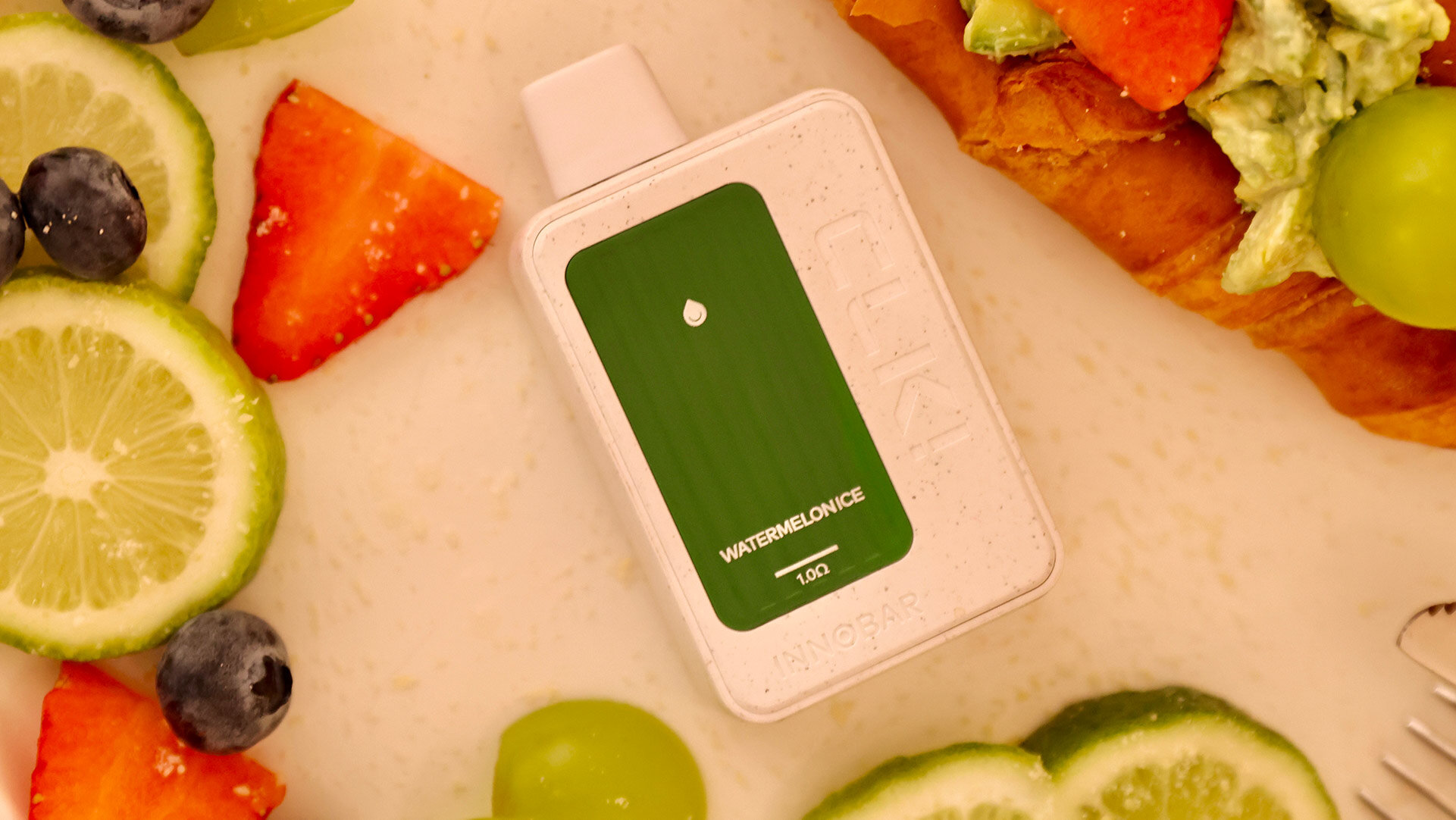 INNOBAR CLK E-Zigarette mit 5.000 Zügen, dargestellt neben buntem Obst und Gemüse, um den Vergleich zu herkömmlichen Zigaretten zu veranschaulichen.