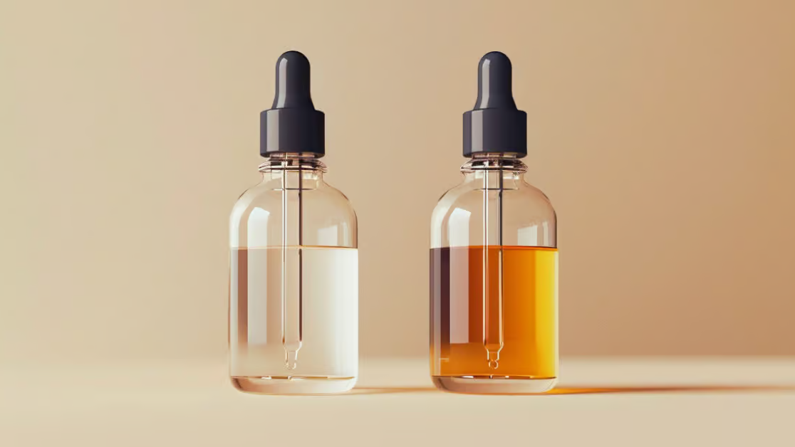 Zwei Tropfflaschen, eine mit klarem Liquid und die andere mit orangefarbenem Liquid, auf einem einfachen Hintergrund, zum Thema "Vape Juice und Ersatzspulen im Ausland kaufen